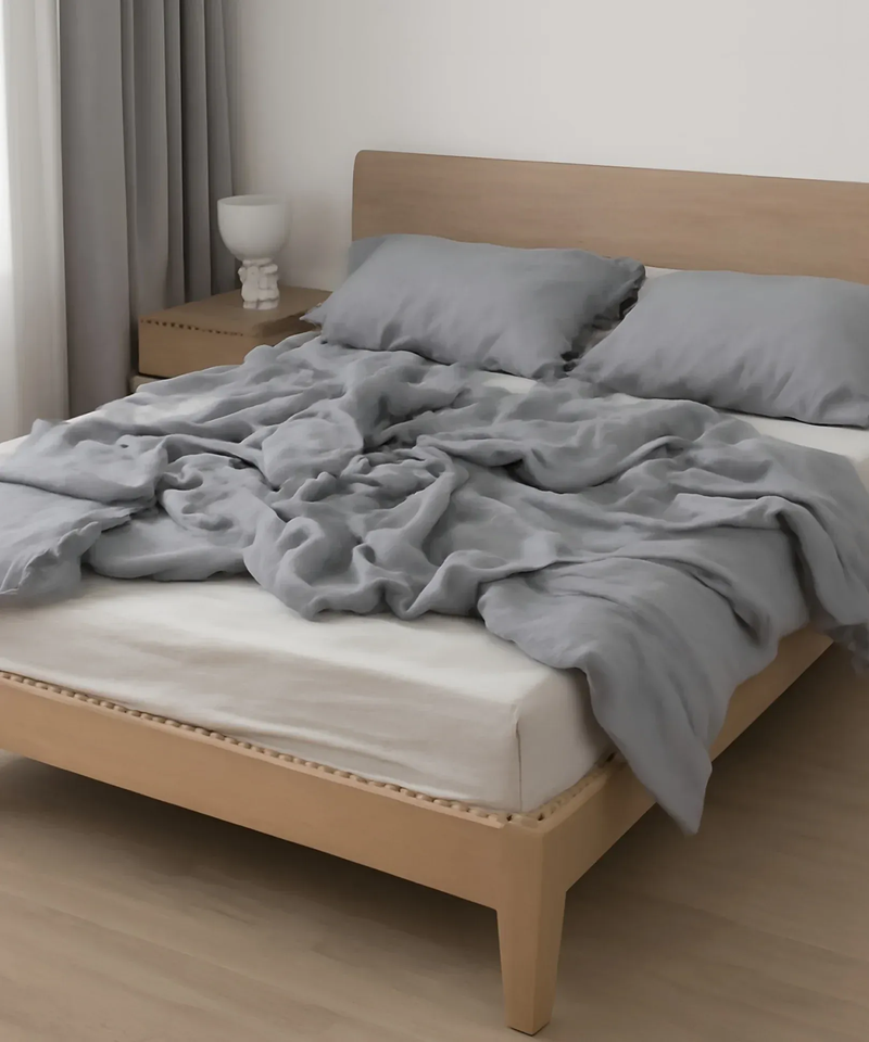 Minimalist bedroom with light wood bed, gray bedding, and modern nightstand decor